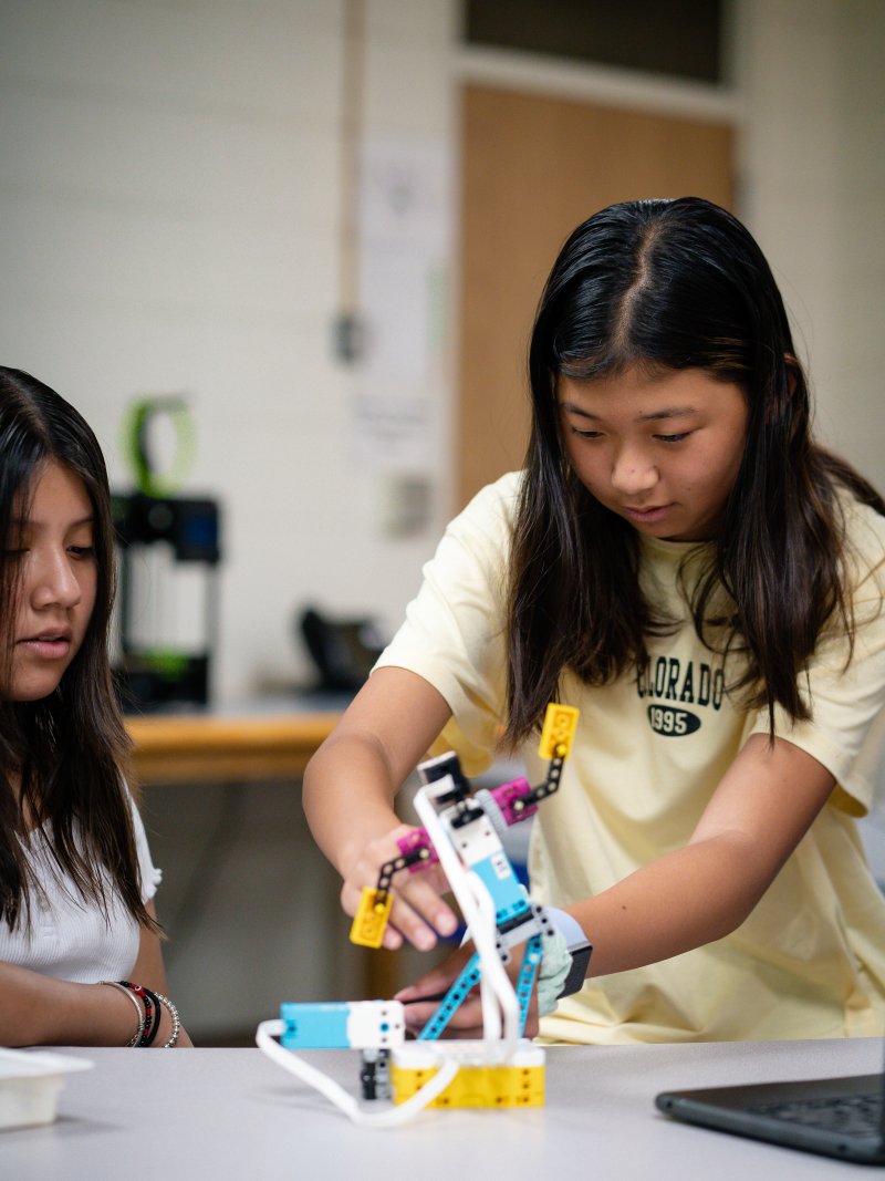 two female students build lego robot