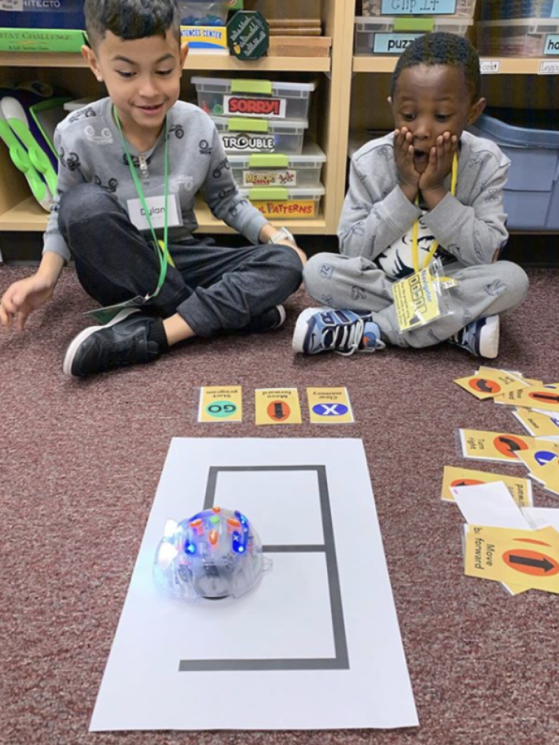 two young students excitedly program beebot navigation
